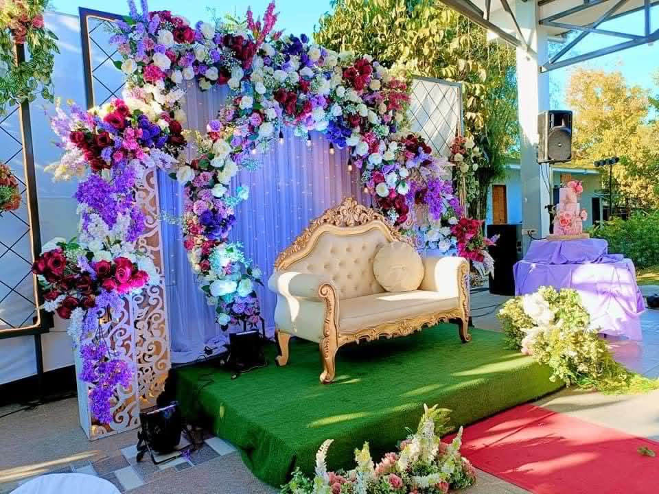 Villa 1 floral photo stage with an ornate sofa and cake table