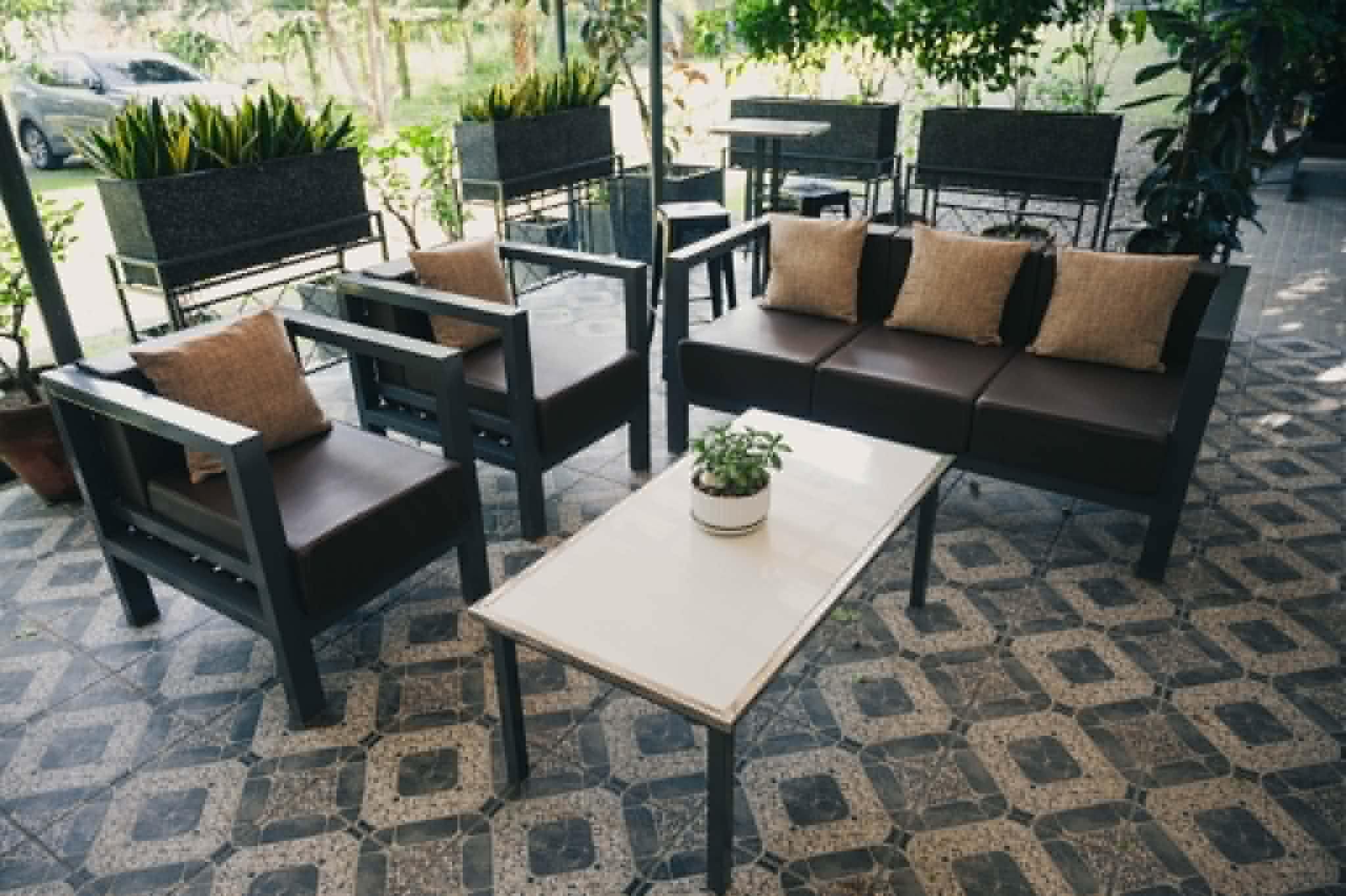 Villa 1 outdoor seating area with sofa chairs and garden views
