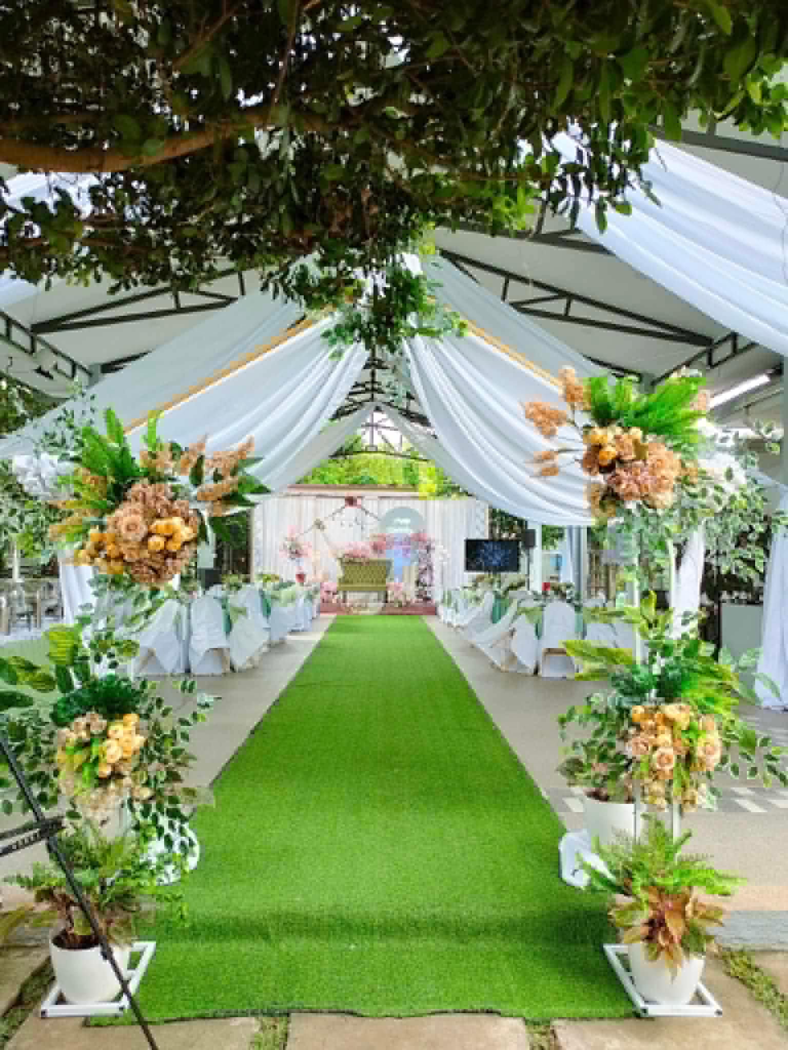 Villa 1 garden aisle setup with white draping and floral stands
