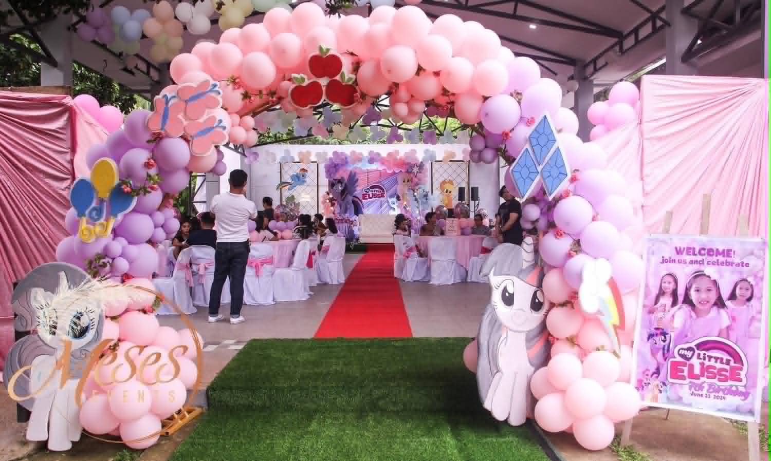 Villa 1 themed party entrance with pink balloons and character decorations