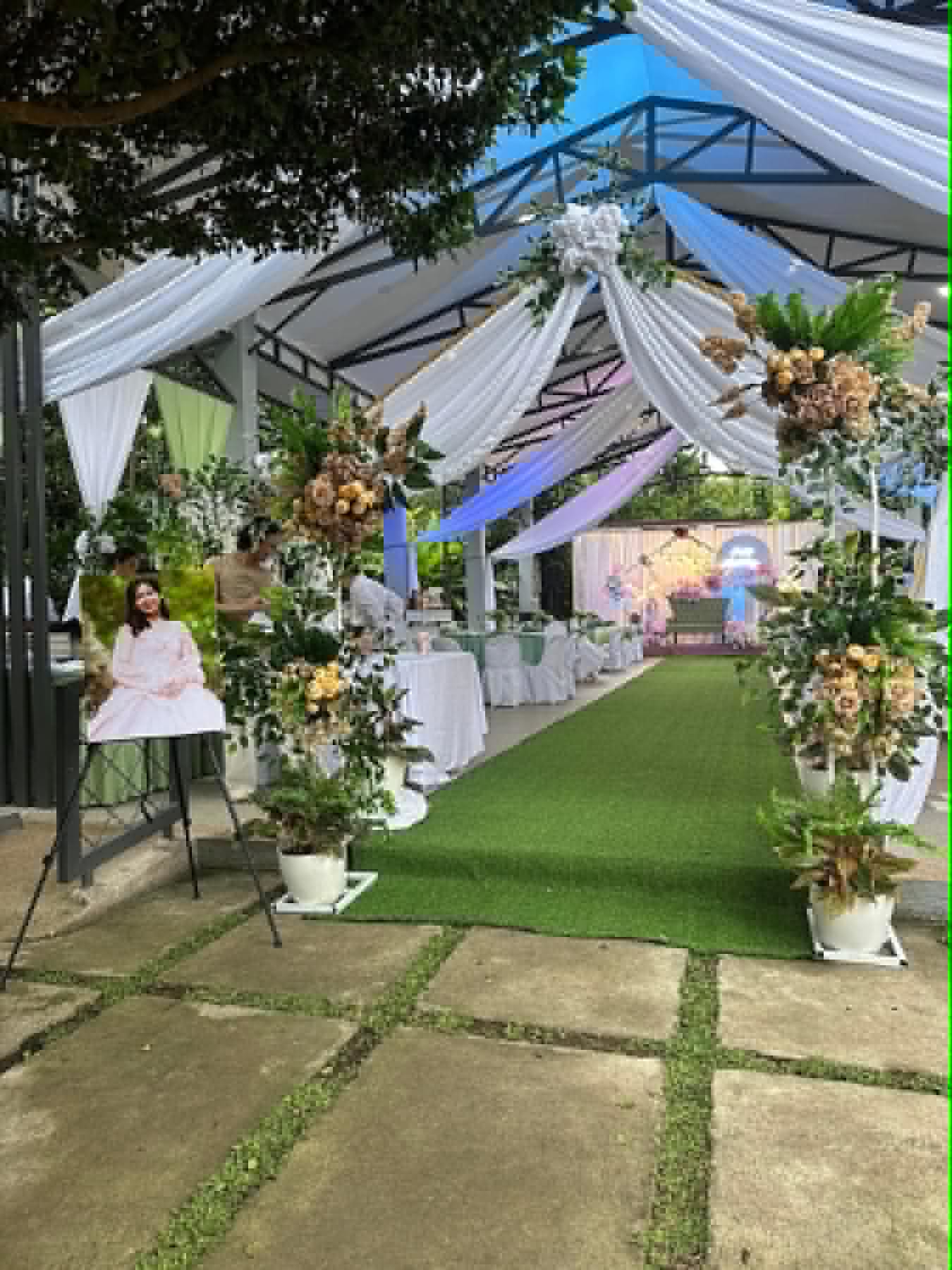 Villa 1 draped event aisle with floral stands and greenery