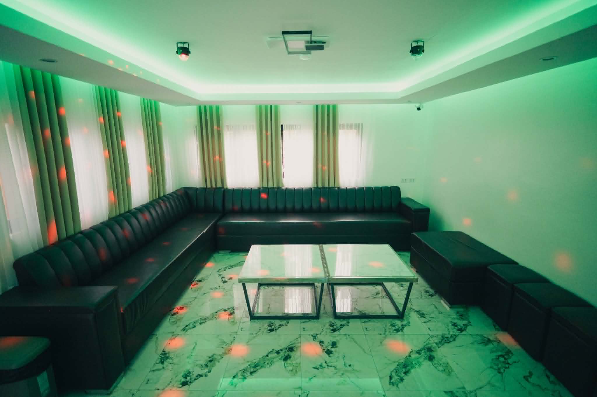 Villa 2 entertainment lounge seating with green ambient lighting