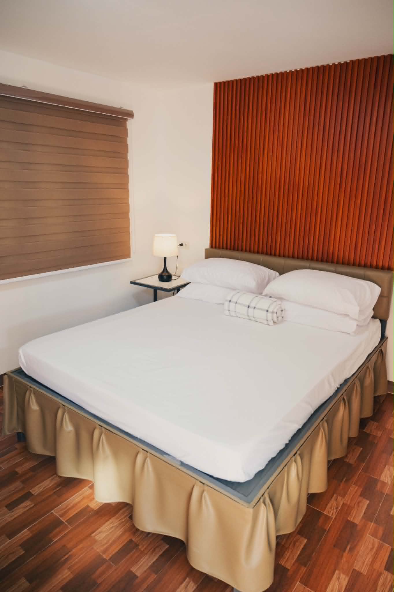 Villa 2 standard room with queen bed and warm wood accent wall