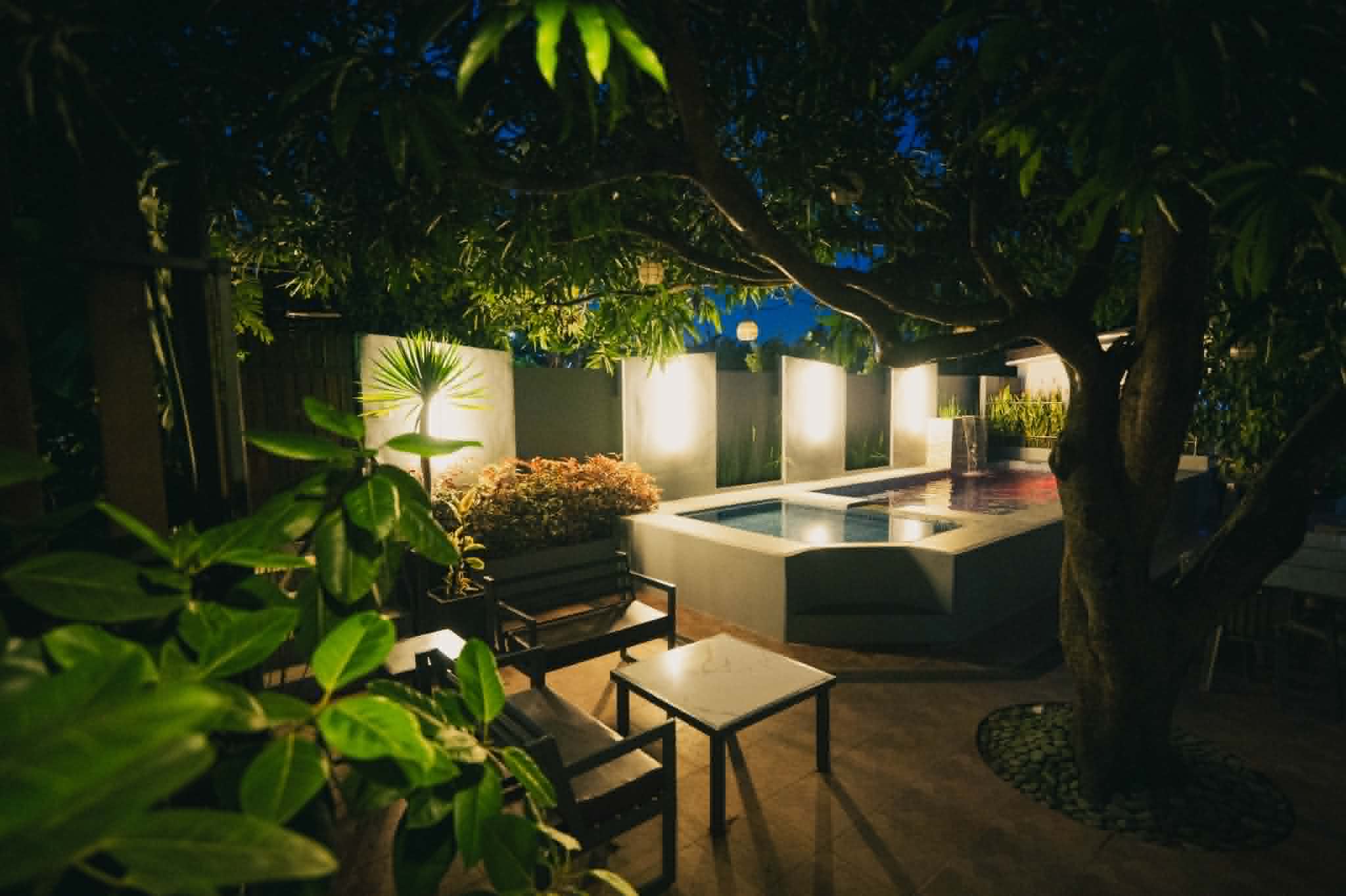 Villa 2 pool and garden seating lit at night